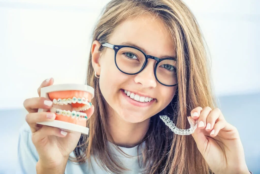 Adult patient holding dental model and aligner representing modern braces for adults